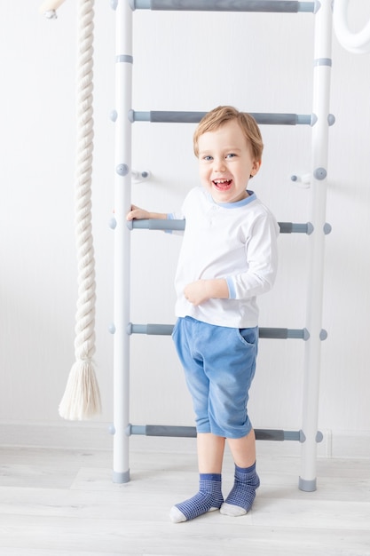 Un bambino un ragazzo si arrampica sul muro svedese della casa