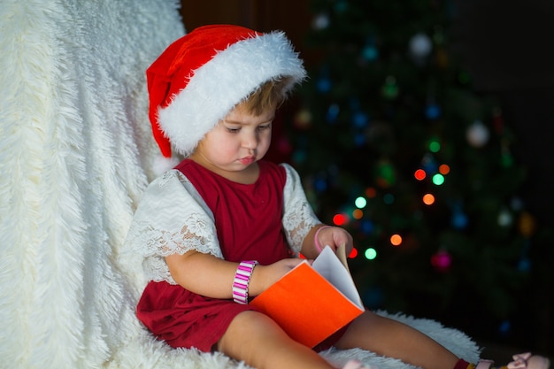 Un bambino vestito di rosso è seduto in attesa del nuovo anno.