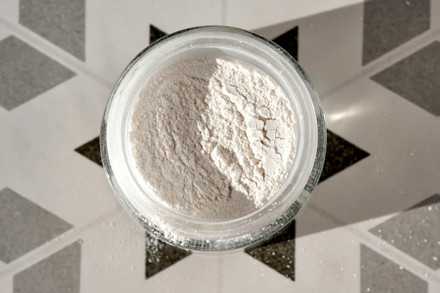 Un barattolo aperto di scrub powder per il viso che mostra la sua consistenza