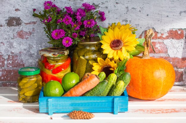 Un barattolo di cetrioli sottaceto e un raccolto di verdure appena raccolte. Melanzane Peperoni e Pomodorini