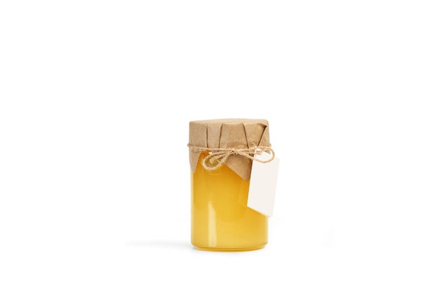 Un barattolo di miele con un'etichetta vuota su uno sfondo bianco con spazio per la copia