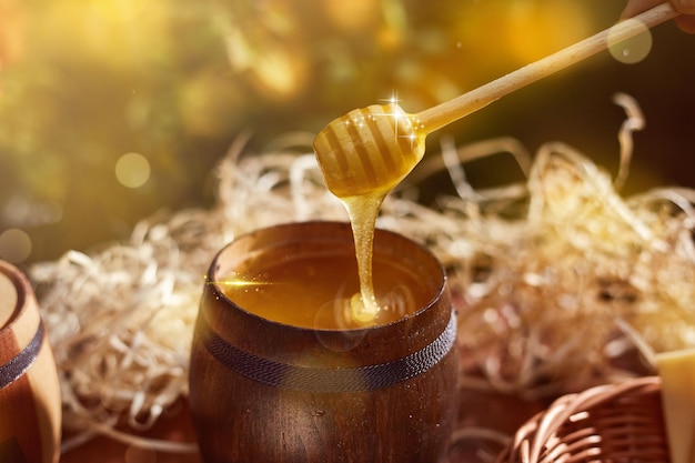 Un barattolo di miele dolce in un secchio su un tavolo di legno