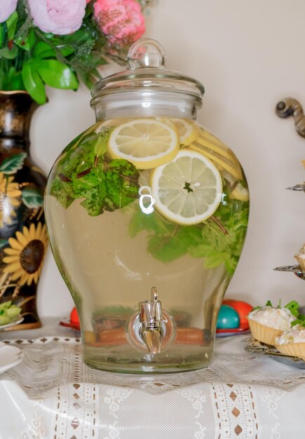 Un barattolo di vetro di limonata con fettine di limone e foglie di menta.