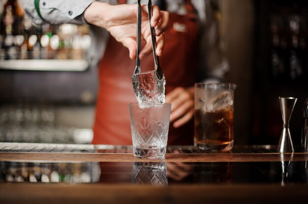 Un barista professionista tiene in mano un ghiaccio.