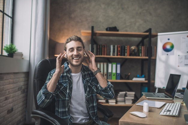 Un bel giovane uomo che utilizza auricolari wireless