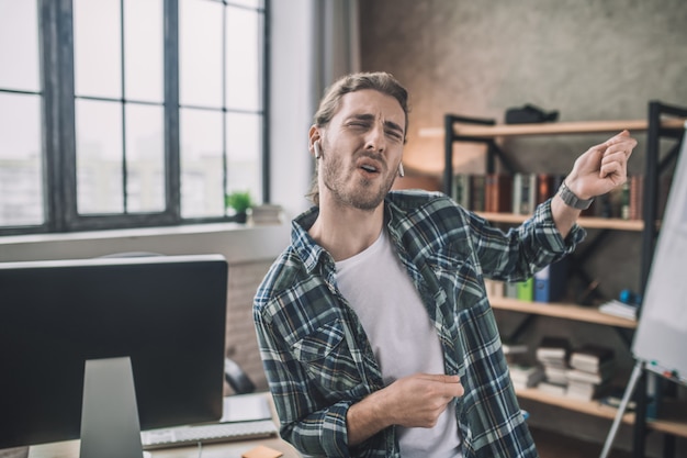 Un bel giovane uomo che utilizza auricolari wireless