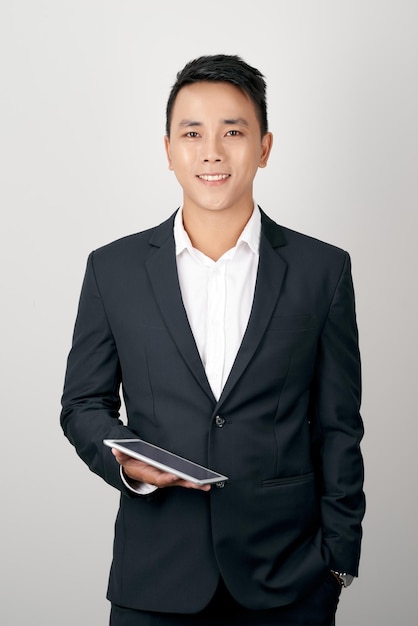Un bel giovane uomo d'affari utilizzando una tavoletta digitale su sfondo bianco