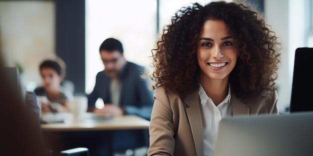 Un bel manager è seduto a una scrivania in un ufficio creativo giovane donna elegante con i capelli ricci usando un portatile in un'agenzia di marketing