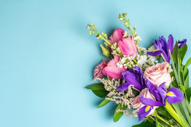 Un bel mazzo di fiori freschi su una superficie pastello blu