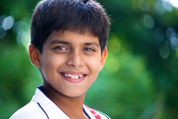 Un bel ragazzo indiano felice e intelligente che guarda nella telecamera Emozioni dei bambini Posto per il testo