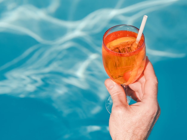 Un bel ragazzo si siede vicino alla piscina.