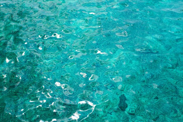 Un bel riflesso del sole che splende sull'acqua blu. Sfondo