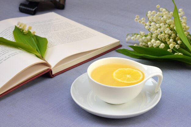 un bel tè di natura morta un bouquet di gigli della valle e un libro