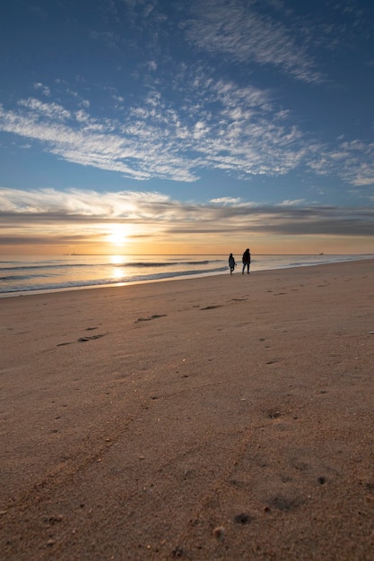 Un bel tramonto sulla spiaggia di Mazagon Spagna profilato da escursionisti sulla riva