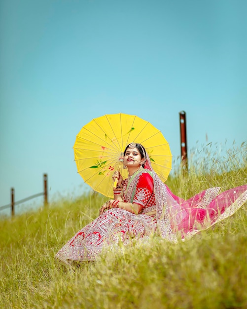 un bel vestito indiano lehnga saree e gioielli con in mano un ombrello cinese