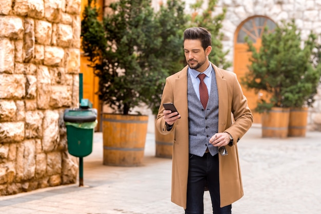 Un bell'uomo elegante con il suo smartphone