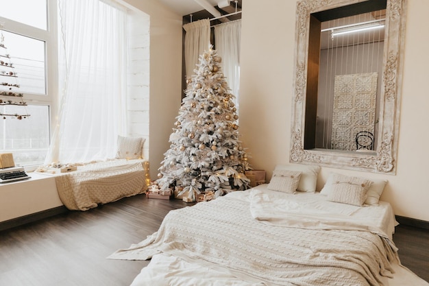 Un bellissimo albero di Natale in un soggiorno decorato con un letto Interni festiviNatale