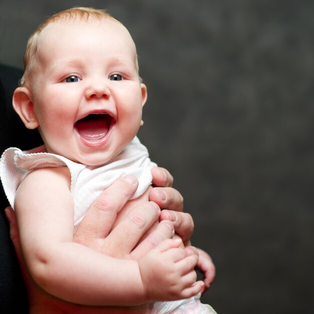 Un bellissimo bambino sorridente nelle mani di suo padre