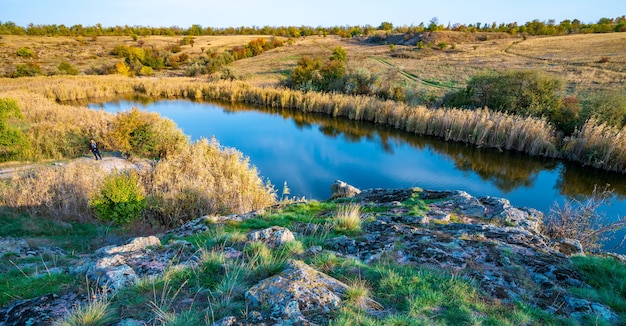 Un bellissimo fiume scintillante tra grandi pietre bianche e vegetazione verde sulle colline in Ucraina