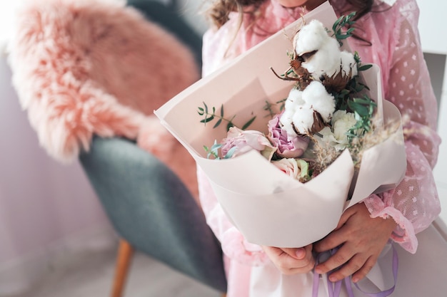 Un bellissimo mazzo di fiori rosa nelle mani di una bambina