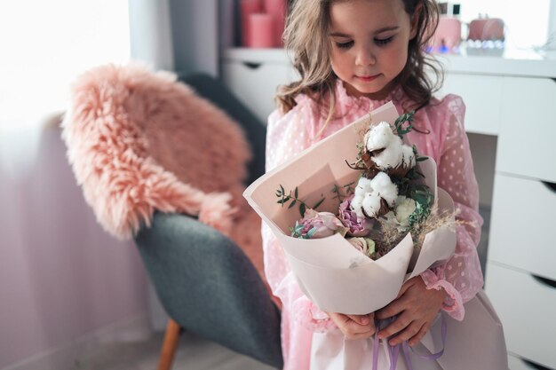 Un bellissimo mazzo di fiori rosa nelle mani di una bambina