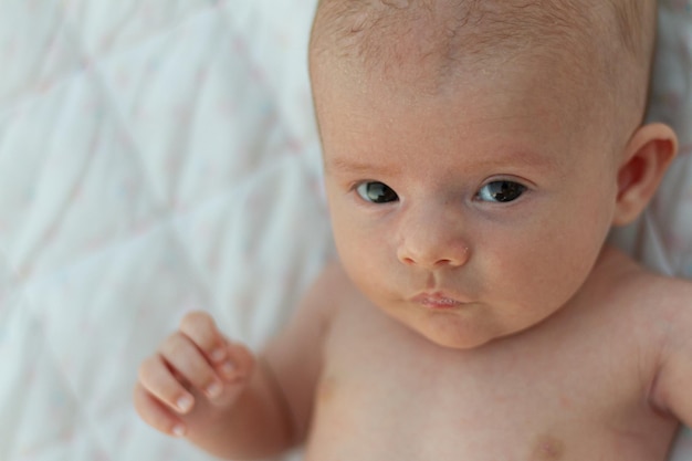 un bellissimo neonato espressivo guarda la telecamera