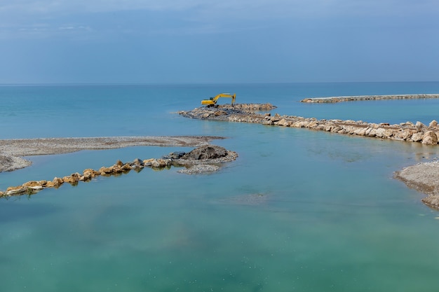 Un bellissimo paesaggio marino con moli in pietra sullo sfondo di un cielo azzurro puro.