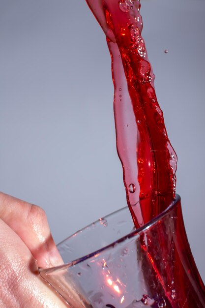 Un bellissimo ruscello di vino rosso in un bicchiere