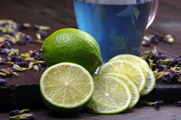 Un bicchiere d'acqua con lime e una tazza d'acqua blu.