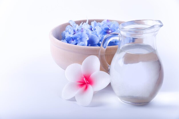 Un bicchiere d'acqua e un fiore su uno sfondo bianco