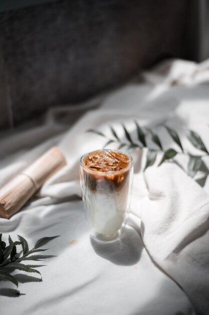 Un bicchiere di caffè ghiacciato con latte sul tavolo