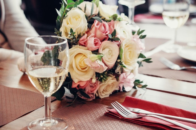 Un bicchiere di champagne con mazzi di rose sullo sfondo