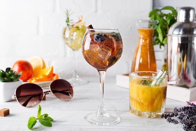 Un bicchiere di cocktail con cannella, frutti di bosco e zucchero di canna e un bicchiere