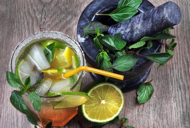 Un bicchiere di cocktail con cannuccia e menta.