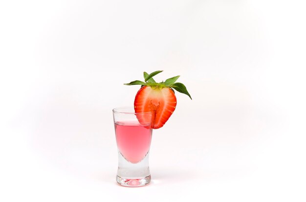 Un bicchiere di cocktail rosa con fragole su sfondo bianco