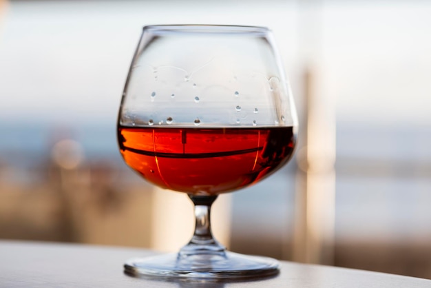 Un bicchiere di cognac su un tavolo di legno al bar.