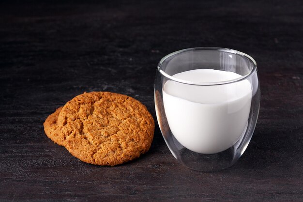 Un bicchiere di latte e biscotti di farina d'avena sul tavolo