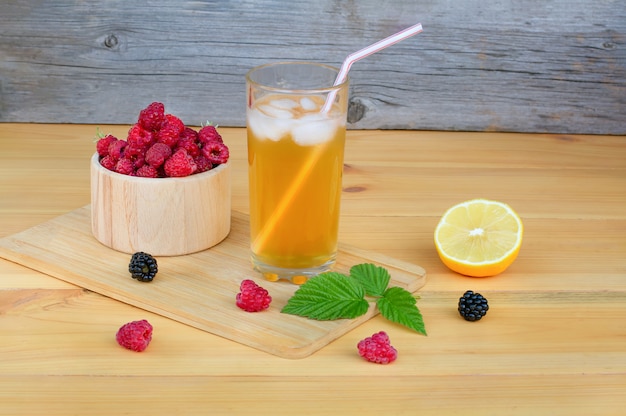 Un bicchiere di limonata con ghiaccio su una tavola di legno.