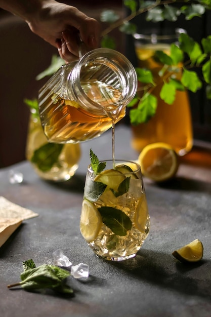 Un bicchiere di mojito al limone e basilico viene versato in un bicchiere.