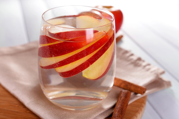 Un bicchiere di sidro di mela con frutta e cannella sul tavolo da vicino