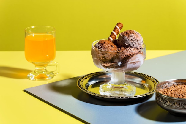 Un bicchiere di succo d'arancia si trova accanto a una coppa di gelato.