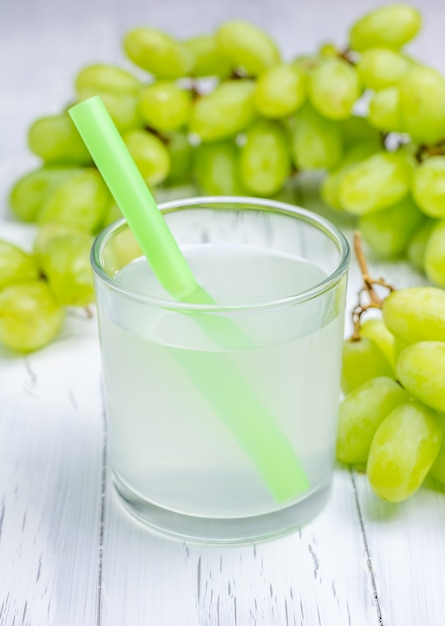 Un bicchiere di succo d'uva e uva sullo sfondo