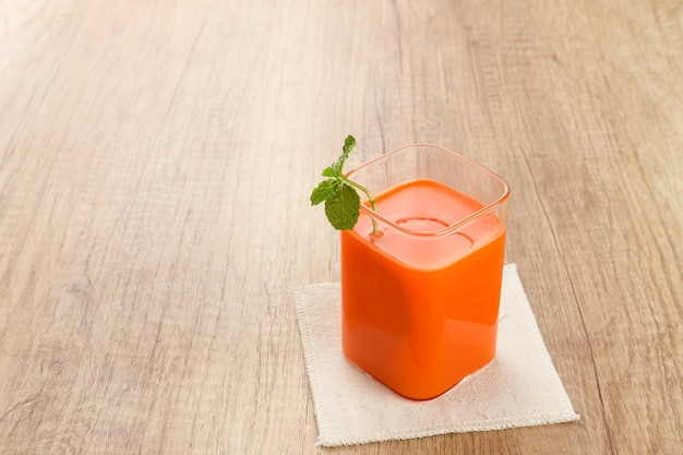 Un bicchiere di succo di carota fresco, molto buono per la salute. Servito in bicchiere. Succo spremuto a freddo