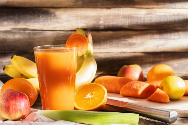 Un bicchiere di succo di carota su uno sfondo rustico