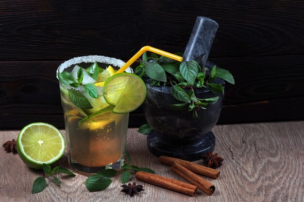 Un bicchiere di tè freddo al limone e foglie di menta.