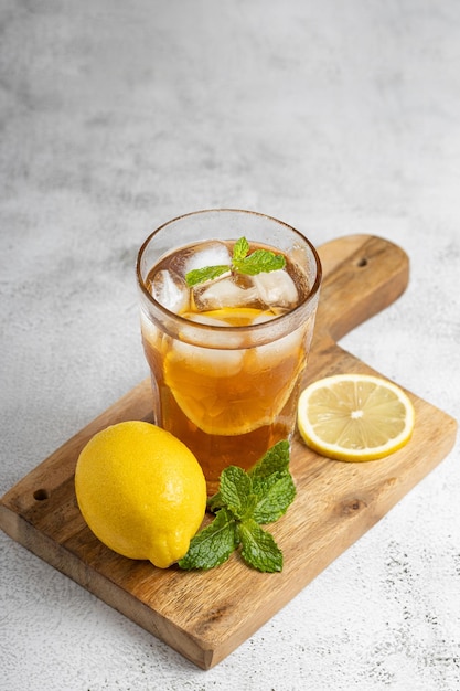 Un bicchiere di tè ghiacciato con limone e menta.