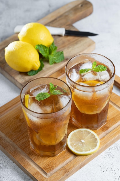 Un bicchiere di tè ghiacciato con limone e menta.