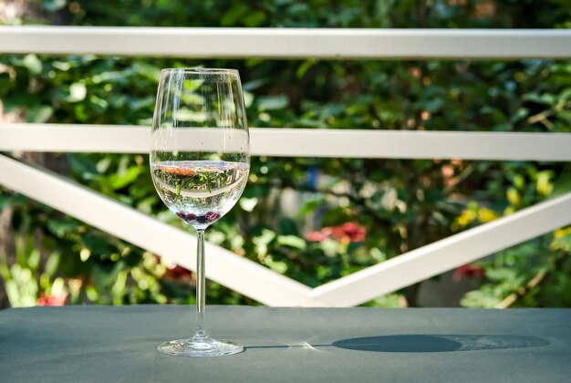 Un bicchiere di vino bianco Minimalismo Un bicchiere d'acqua sullo sfondo del giardino