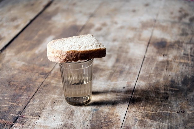 Un bicchiere di vodka e un pezzo di pane su un tavolo di legno