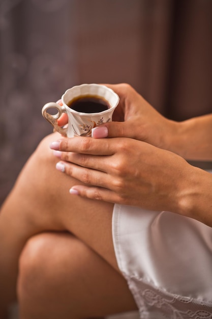 Un bicchierino di caffè nelle mani delle donne 4260